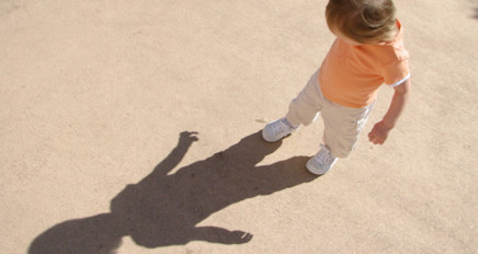 Photo of a child playing with their shadow 