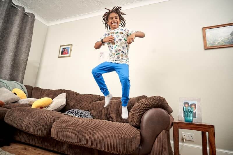 Image of a child laughing and jumping on a sofa.