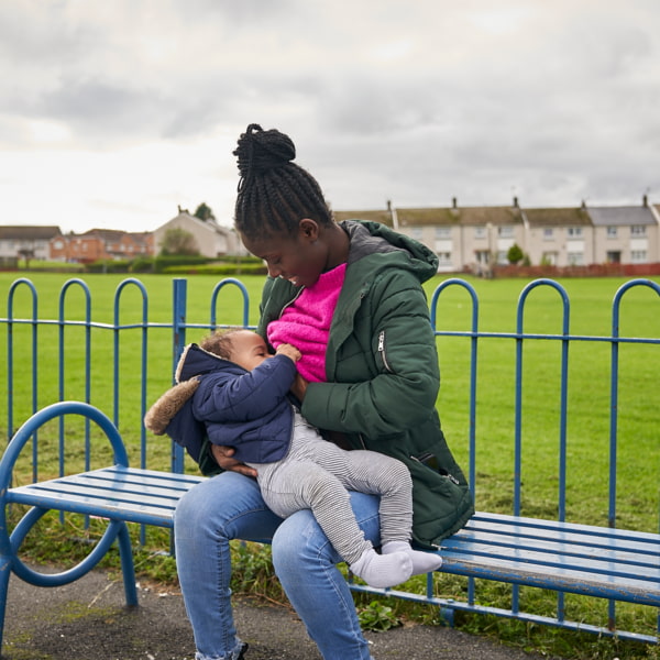 Photo of a mother breastfeeding on a park bench
