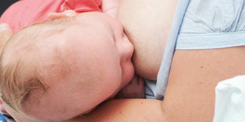 Photo of a newborn baby being breastfed