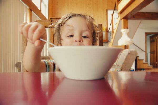 Photo of a child eating from a bowl 